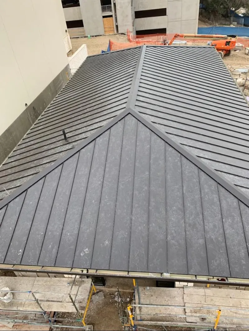 Commercial metal roof construction with crane equipment in Carpentersville